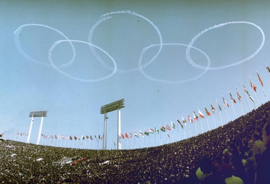 Jatos da Força Aérea do Japão desenham o símbolo olímpico no céu durante a cerimônia de abertura dos Jogos de 1964.