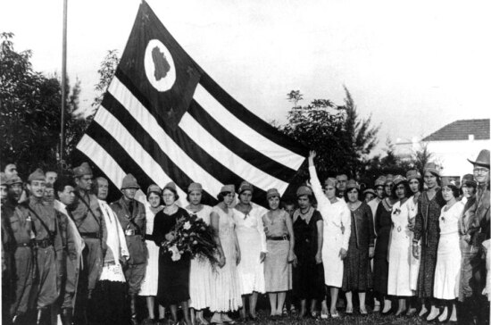 Soldados e enfermeiras hasteiam bandeira paulista. 