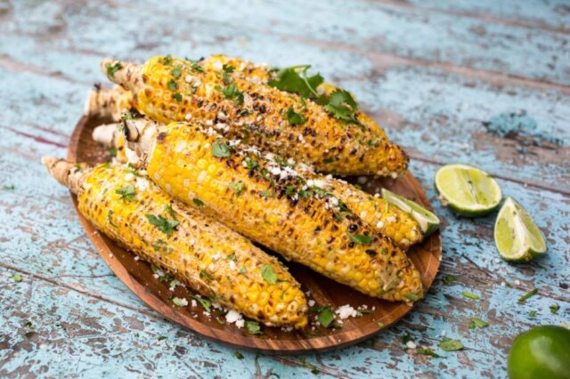 Andrew Scrivani|NYT Elote, comida de rua popular do México: milho na grelha com queijo, maionese e coentro.