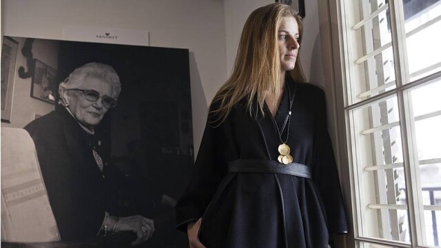 Rina Castelnuovo/The New York Times Sharon Tal, que dirige a marca Maskit em Tel Aviv ao lado do marido, em frente ao retrato de Ruth Dayan, fundadora da grife