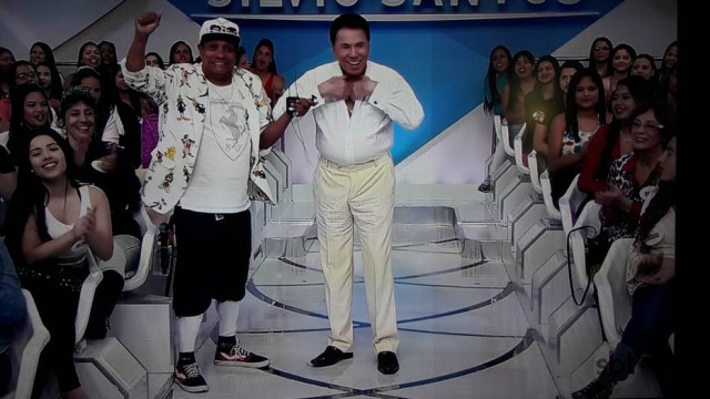 Reprodução Silvio Santos simulando striptease ao vivo.
