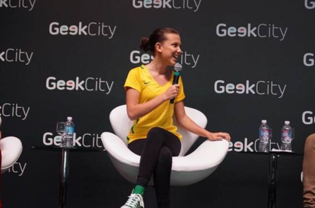 Divulgação/Geek City/Excom Millie Bobby Brown em evento de cultura pop em Curitiba (PR), vestindo camiseta com as cores do Brasil.