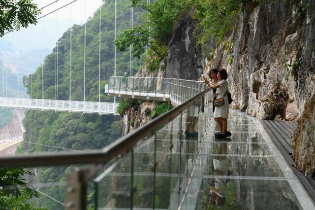 Nhac NGUYEN / AFP O Vietnã lançou uma nova atração para turistas: a abertura de um ponte com fundo de vidro suspensa cerca de 150 metros acima de um exuberante desfiladeiro coberto de selva.