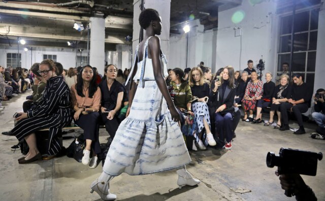 Bebeto Matthews/AP Photo Conjunto de top e saia em denim superlavado sobre botas de cano alto do verão 2019 da Proenza Schouler