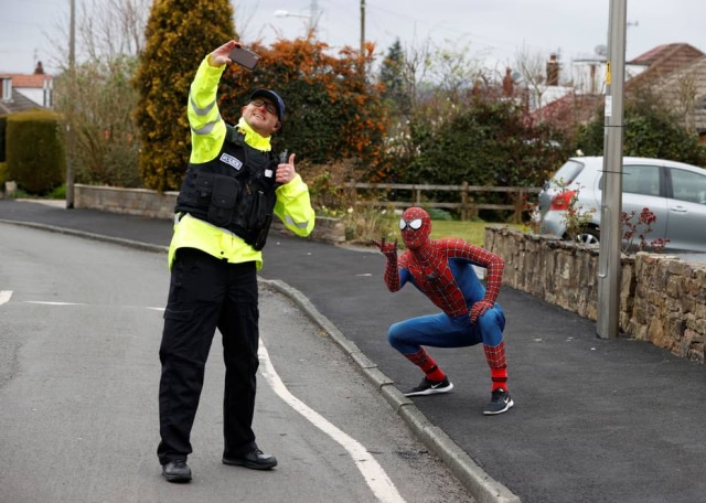Phil Noble / Reuters O professor Jason Baird vestido como Homem-Aranha durante período de quarentena na cidade de Stockport, na Inglaterra.