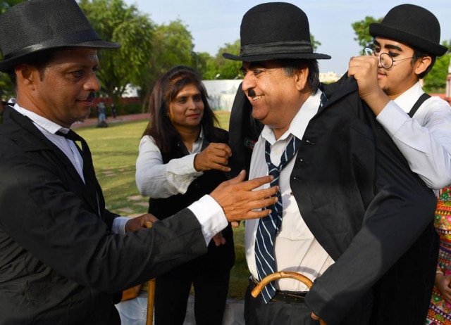 Indranil Mukherjee/AFP Photo Ashok Aswani se prepara para o desfile em homenagem a Charles Chaplin.