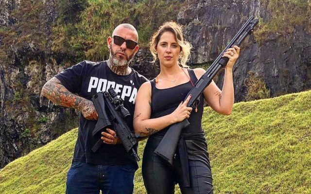 Instagram/@henrique_fogaca74 Henrique Fogaça posa ao lado da mulher, ambos segurando armas.