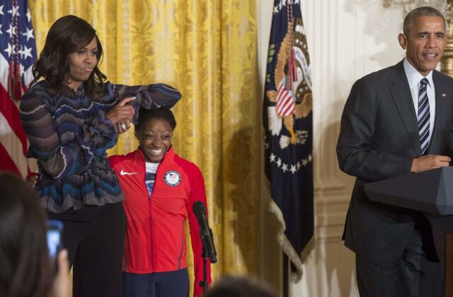AFP PHOTO/SAUL LOEB Michelle Obama faz poses brincando com a altura da ginasta olímpica Simone Biles.