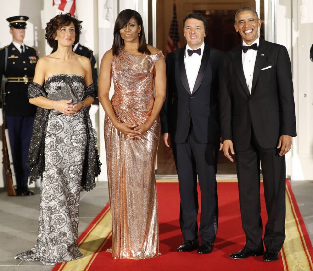 AP Photo/Pablo Martinez Monsivais Assinado pela estilista italiana Donatella Versace, o vestido rosé brilhante, com decote assimétrico e drapeado na cintura, mostra como Michelle evoluiu.
