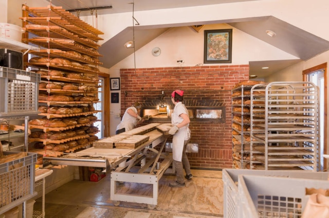 Oliver Parini/NYT Blair Marvin, à esquerda, e sua assistente, Sophia Berard assam os pão no forno a lenha