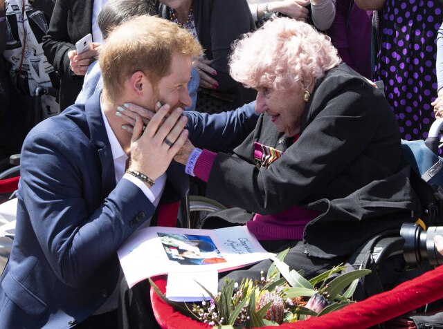 Paul Edwards / Pool via AP O príncipe Harry durante encontro com Daphne Dunne, de 98 anos, em frente à Opera House em Sydney, Austrália. Harry está em viagem de 16 dias à Austrália e a outras ilhas do sul do Pacífico.