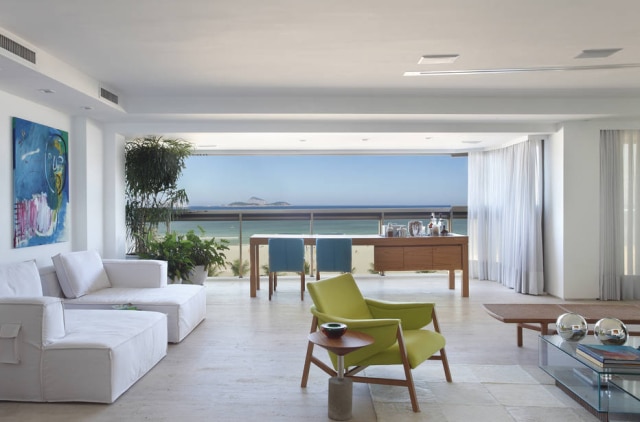MCA Estúdio O living deste apartamento no Rio, incorporou a antiga varanda e agora tem 82 metros quadrados. O piso de mármore travertino bruto tem o tom da area da Praia de Ipanema, neste projeto de Roberta Moura, Paula Faria e Luciana Mambrini