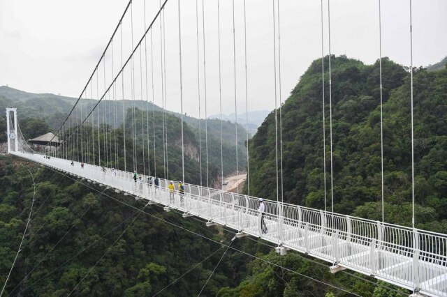 Nhac NGUYEN / AFP Visitantes caminham na ponte de vidro Bach Long, no distrito de Môc Châu, na província de Son La, no Vietnã.