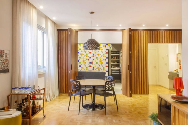 Zeca Wittner/Estadão O painel de ripas de madeira separa a cozinha do living quando necessário. O carrinho de chá, que serve como bar, é da Desmobilia