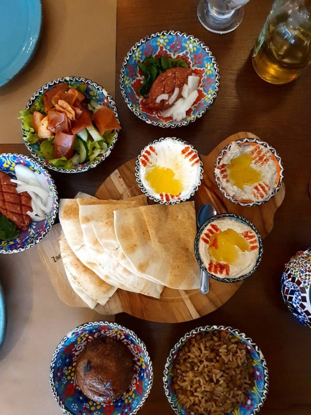 Mesa fica cheia de lindos potinhos libaneses coloridos com pastas, saladas, arrozes, assados, quibes…Tudo delicioso, fresquinho.
