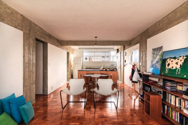 Rafael Monteiro/Divulgação Vista da sala de estar para a cozinha. As poltronas Paulistano, de Paulo Mendes da Rocha, vieram da antiga casa do casal