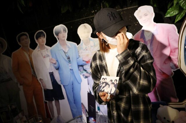 Kim Hong-Ji/ Reuters Nini Lee, uma fã sul-coreana da boyband de K-pop BTS, chora durante uma entrevista em um café com produtos do BTS em Seul, Coreia do Sul, em 15 de junho de 2022.