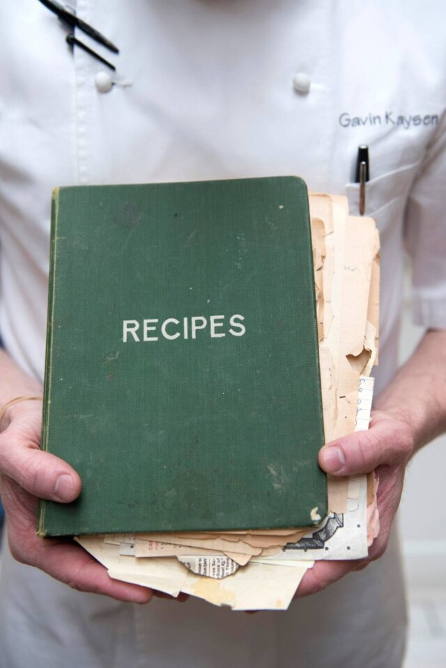 Angela Jimenez|NYT Carne de panela tem sabor e aroma de comida caseira. Aqui, o chef Kaysen segura o livro de receitas de sua avó, Dorothy.