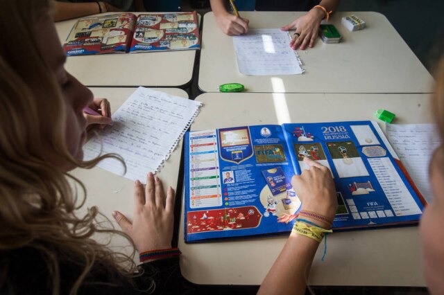 Amanda Perobelli/Estadão Estudantes usam álbum da Copa durante aula em escola de São Paulo.
