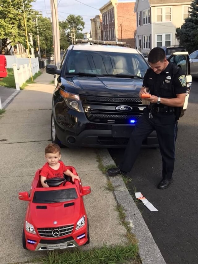 Grayson Salerno, de apenas um ano de idade, sendo 'multado' por dirigir seu 'Mercedes' vermelho.