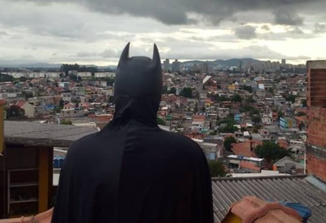 PerifaCon / Divulgação Jovem fantasiado de Batman olhando para o horizonte de casas do Capão Redondo.