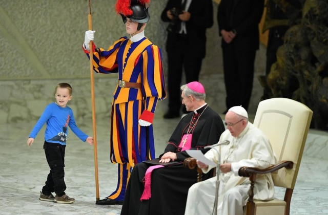 Ettore Ferrari/EFE Menino com autismo brinca com guarda suíço em audiência no Vaticano.