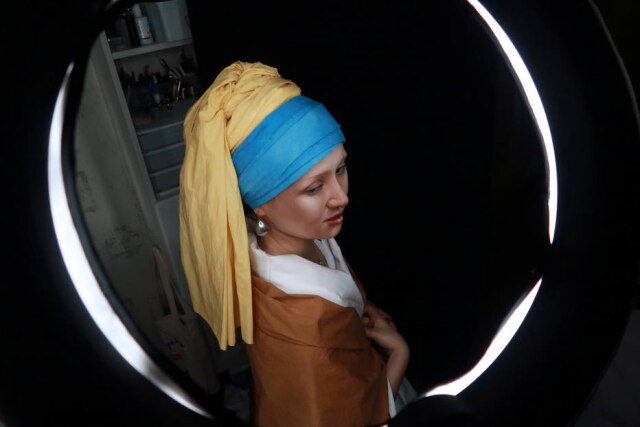 REUTERS/Thomas Suen A maquiadora He Yuhong se transformando em 'Moça com Brinco de Pérola', pintura do século 17 de Johannes Vermeer.