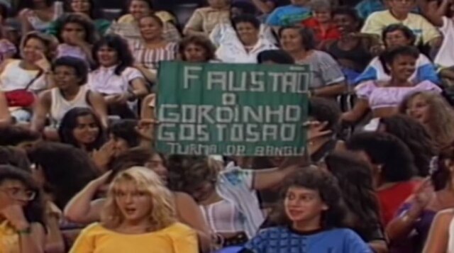Reprodução de 'Domingão do Faustão' (1989) / Globo Fã leva cartaz à plateia do primeiro 'Domingão do Faustão'.