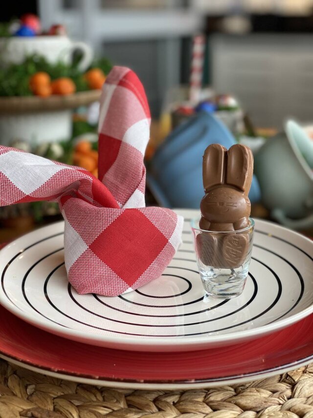 Giselle Martos Dobre seus guardanapos sugerindo orelhas de coelho. Depois, posicione ao lado dele um chocolate no formato do símbolo da Páscoa e decore cada um dos pratos da mesa.