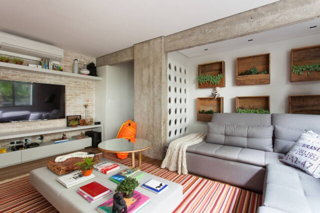 Ricardo Basseti/Divulgação No living, sofá da Star Móveis e pufe usado como mesa de centro. A mesa espelhada é da Clami design. No piso, madeira de demolição