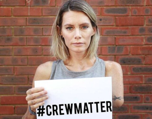 Instagram / @oliviathebandit A dublê Olivia Jackson com uma placa que diz 'A Equipe Importa', alertando para acidentes com envolvidos em gravações de filmes