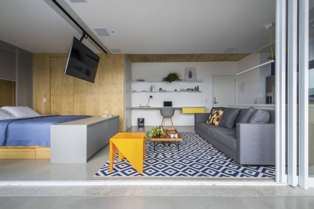 Quadra 2 Arquitetura/Divulgação O lavabo e o banheiro ficam camuflados na parede onde foi instalado o painel de madeira pinus
