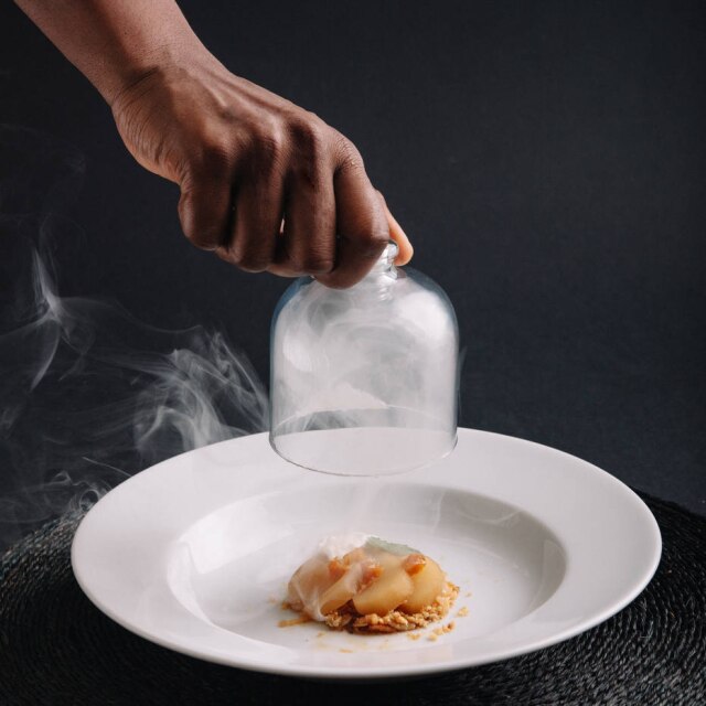 Acervo pessoal Na mesa. Pera cozida e defumada com rooibos e crumble de gengibre, creme de amarula, do restaurante Midunu