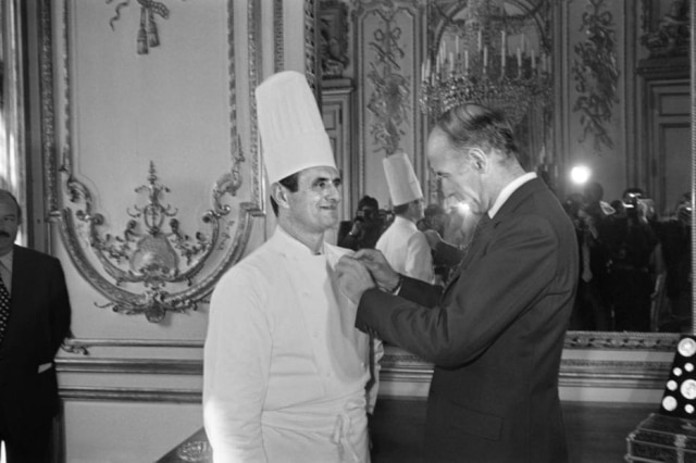 Em 25 de fevereiro de 1975, Paul Bocuse recebe a medalha da Legião de Honra das mãos do então presidente francês Valery Giscard d'Estaing.