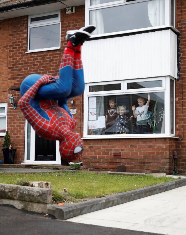 Phil Noble / Reuters O professor Jason Baird vestido como Homem-Aranha durante período de quarentena na cidade de Stockport, na Inglaterra.
