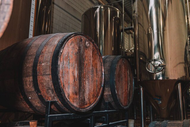 Tales Hideki Barris de madeira e tanques de inox na fábrica da cervejaria Dádiva.