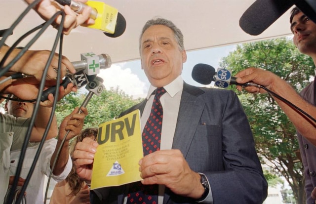 Wilson Pedrosa/Estadão O ministro da Fazenda Fernando Henrique Cardoso segura a cartilha da URV (Unidade Real de Valor) enquanto concede entrevista na porta do Ministério, em Brasília, DF. 01/3/1994. Foto: Wilson Pedrosa/Estadão