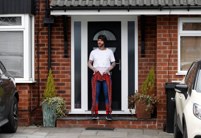 Phil Noble / Reuters O professor Jason Baird vestido como Homem-Aranha durante período de quarentena na cidade de Stockport, na Inglaterra.