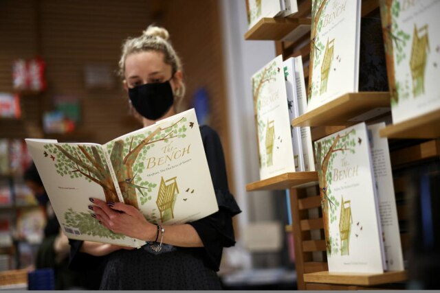REUTERS/Henry Nicholls Mulher lê livro 'The Bench', da duquesa de Sussex, em Londres, Reino Unido.