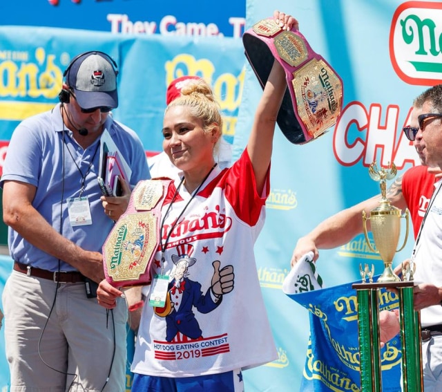 Justin Lane / EFE / EPA Miko Sudo recebe o prêmio após comer 31 hot dogs em 10 minutos em 2019.