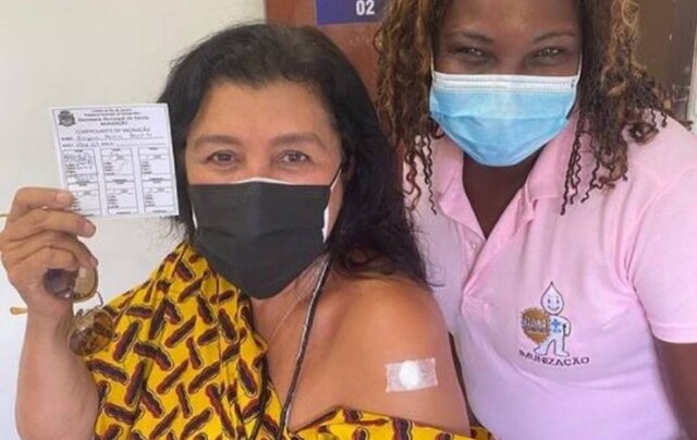 Instagram/ @reginacase Regina Casé posa com a agente de saúde e mostra carteira de vacinação