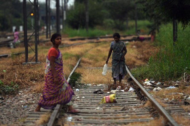 Prakash Singh / AFP Mulheres caminham nos trilhos da estação de trem Nizamuddin, em Nova Delhi. A área é conhecida por ser um espaço aberto onde as pessoas costumam defecar. A foto foi tirada em 27 de setembro de 2019.