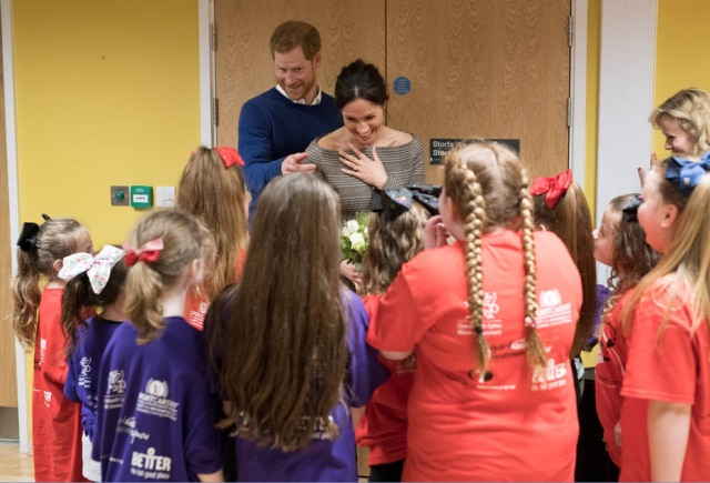 Geoff Pugh/Reuters Príncipe Harry e Meghan Markle interagem com crianças em uma comunidade de recreação no País de Gales.
