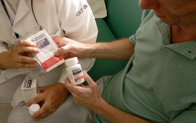 Portador do vírus HIV recebe coquetel de remédios de enfermeira do Centro de Treinamento em DST/AIDS, em São Paulo. 