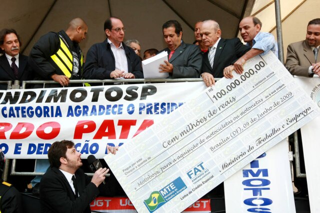Valéria Gonçalvez / Estadão Danilo Gentili tenta pegar cheque simbólico em evento no Sindimoto de São Paulo, no bairro de Santa Cecília, que contava com a presença do então ministro do Trabalho, Carlos Lupi.