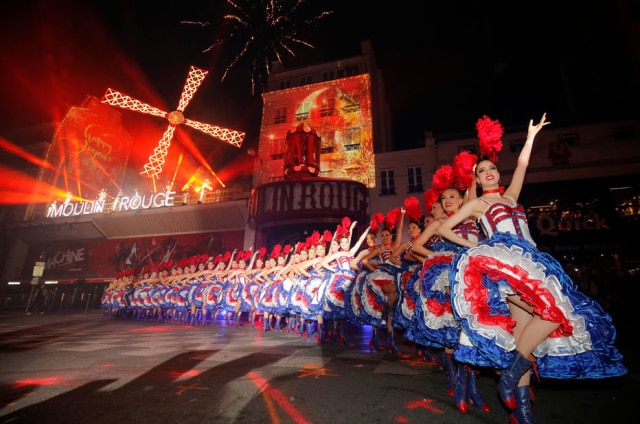 Philippe Wojazer/REUTERS Dançarinas françesas comemoram os 130 anos de Moulin Rouge com performance em frente ao local