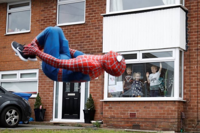 Phil Noble / Reuters O professor Jason Baird vestido como Homem-Aranha durante período de quarentena na cidade de Stockport, na Inglaterra.