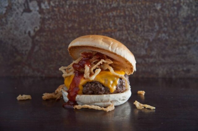 Rogerio Gomes|Divulgação Austin burger, que leva carne na brasa com cheddar, molho barbecue e cebola crocante