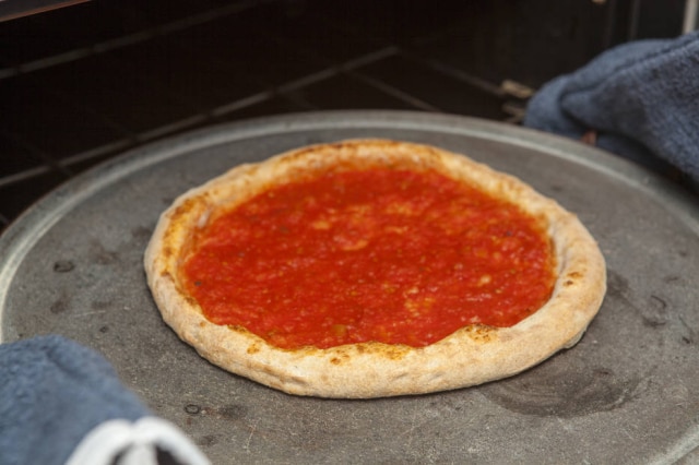 Asse a pizza em duas etapas. Primeiro, só com o molho.