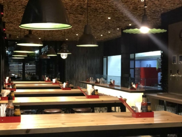 Marcos Livi Ambiente com elementos que remetem ao fogo na nova hamburgueria do Mercado de Pinheiros